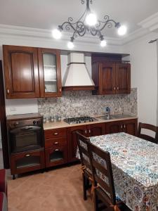una cocina con una mesa y una estufa horno superior en Dolce Rifugio, en Siculiana