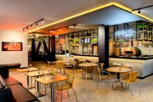 un restaurant avec des tables et des chaises et un bar dans l'établissement ibis Sao Paulo Paulista, à São Paulo