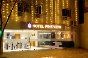 a hotel entrance with chairs in front of a building at Hotel Pine View in Rajkot