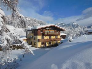a building in the snow with snow covered trees at Ferienwohnung Habel in Hochfilzen +9 photos