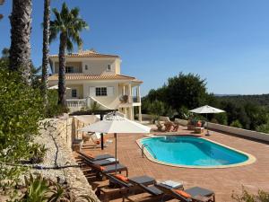 eine Villa mit einem Swimmingpool vor einem Haus in der Unterkunft Villa Botanica in Canhestros
