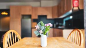 a white vase with flowers on a wooden table at Clarion Village in Sligo