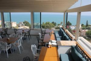 een restaurant met tafels, stoelen en ramen bij Port Marina Hotel in Karatas