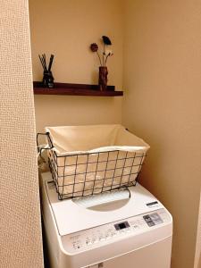 a washing machine with a basket on top of it at Wa Shinsaka 902 7minute walk from Shinsakacho Station Maximum 4 people Separate bath and toilet Washing machine with dryer in Nagoya