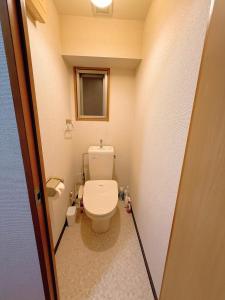 a small bathroom with a toilet and a window at Wa Shinsaka 902 7minute walk from Shinsakacho Station Maximum 4 people Separate bath and toilet Washing machine with dryer in Nagoya