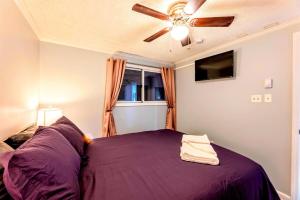 - une chambre avec un lit violet et un ventilateur de plafond dans l'établissement Snowshoe Ski In Ski Out Renovated 2BR, à Snowshoe