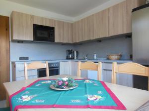 a kitchen with a table with a plate of flowers on it at Ferienwohnung Habel in Hochfilzen