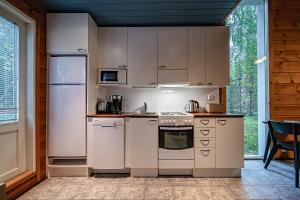 a kitchen with white appliances and a window at Aurelfox Chalet A by Aavalevi in Levi