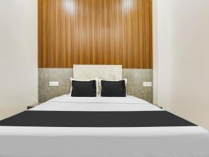 um quarto com uma grande cama branca com dois travesseiros em Hotel O Green In em Bathinda mais 22 fotografias