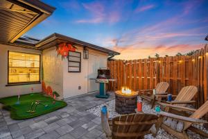 a patio with a table and chairs and a fireplace at Saltwater Siesta Game Room Pool Mini Golf in Sarasota