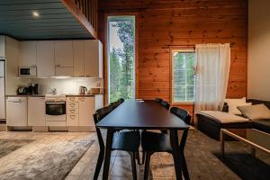 a kitchen and living room with a table and a couch at Aurelfox Chalet A by Aavalevi in Levi +23 photos