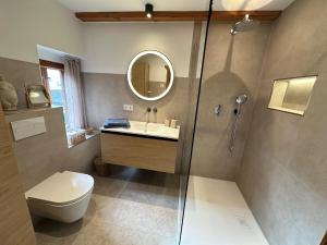 a bathroom with a toilet and a sink and a mirror at RitterLiving Ferienapartment am Markt in Tangermünde
