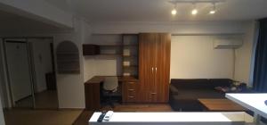 a living room with a couch and a desk at Studium Green Apartman in Cluj-Napoca