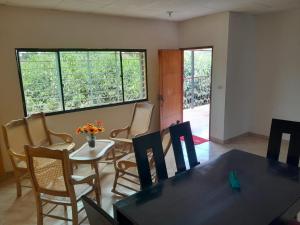 a dining room with a table and chairs and windows at Bonito Apartamento en Mompox in Santa Cruz de Mompox