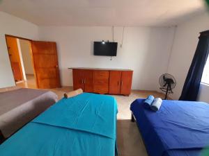 une chambre avec deux lits et une télévision à écran plat dans l'établissement Bonito Apartamento en Mompox, à Santa Cruz de Mompox