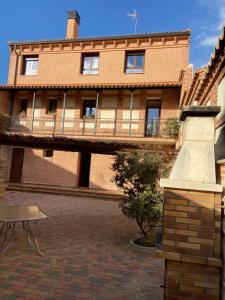 a large brick building with a balcony on top of it at Casa Rural San Isidro in Valdepiélagos