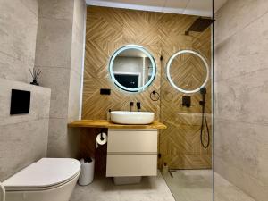 un baño con lavabo y espejo en Jarzebinowa Loft III by JumpInHere, en Nowy Dwór Mazowiecki