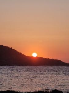una puesta de sol sobre el océano con la puesta de sol en una colina en O Curro de Arou, en Arou