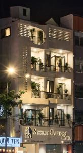 ホーチミン・シティにあるSecret Garden Phan Xich Long - Địa chỉ - Addr 99 Phan Xich Long, Phú Nhuậnの夜にバルコニーに植物が置かれた建物