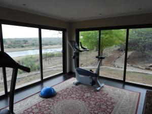 a room with a gym with a treadmill and windows at Buffalo Brooke in Hectorspruit