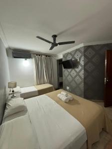 a bedroom with two beds and a ceiling fan at Hotel Nuevo Suizo in San Juan