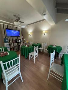 a dining room with green tables and white chairs at Hotel Nuevo Suizo in San Juan