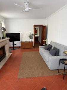 a living room with a couch and a tv at Casa de S Bento in Santarém