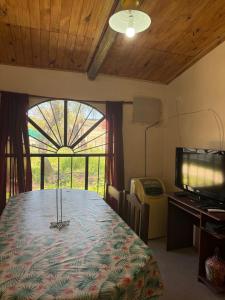 a room with a table with a television and a window at Complejo en camino de la costa in Gualeguaychú