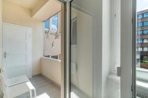 a glass shower door in a bathroom with a chair at Hallerstraße - 4 Wohnungen in Pforzheim