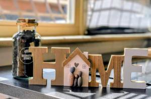 a wooden house sign sitting on top of a counter at Momy's Home Rome in Rome +25 photos