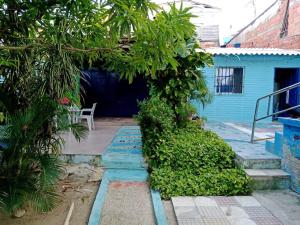 a courtyard with a blue house with a tree at Villa mar in Puerto Colombia