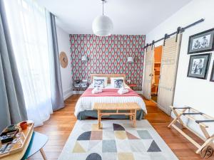 a bedroom with a bed and a red wall at La Demeure Numéro 5 in Cambrai
