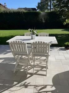 a white table with two chairs and a potted plant at Chambre d'hotes à Laroin in Laroin