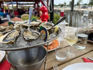 a plate of oysters on a table with wine glasses at Le Cabanon du Marché in Audenge +23 photos
