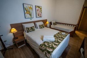 Una cama o camas en una habitación de Vale das Orquídeas Pousada
