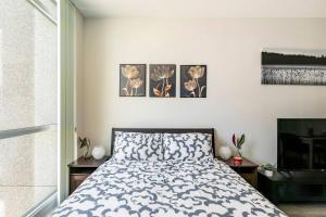 a bedroom with a bed and three paintings on the wall at Address - 215 Fort York Blvd M5V Steps to ROGERS Centre and lakeside - Free Parking in Toronto