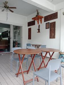 een eetkamer met een houten tafel en stoelen bij OhoWowGood in Chiang Mai