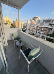 a balcony with a chair and a pillow and a table at Boutique apartment in Rishon LeẔiyyon