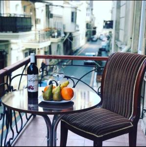 una mesa con una botella de vino y fruta en el balcón en City Inn Boutique Hotel, en Baku