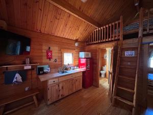 a kitchen with a red refrigerator in a wooden cabin at Katie's Cozy Cabins in Tombstone +21 photos