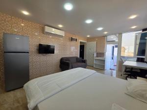 a bedroom with a large white bed and a television at B21 Studio At Dar Al Hoboor دار الحبور in Seeb