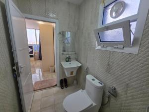 a bathroom with a white toilet and a sink at B21 Studio At Dar Al Hoboor دار الحبور in Seeb +37 photos