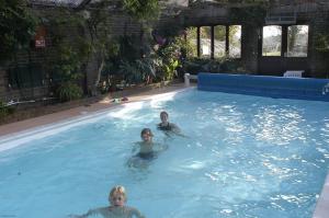 two children are swimming in a swimming pool at Pekes Tudor View in Hailsham