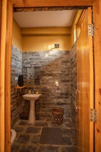 een badkamer met een stenen muur en een wastafel bij The Winter Courtyard by AVVAs Stays in Bir