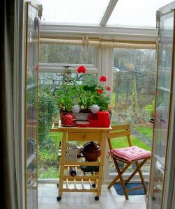 a table with flowers on it in front of a window at 80 Rushes Road, Petersfield GU32 3BP in Petersfield