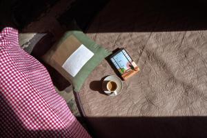 een mobiele telefoon op een bed met een kopje koffie bij The Winter Courtyard by AVVAs Stays in Bir +29 foto's
