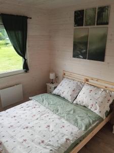 a bedroom with a bed and a window at Domek Leśna Przystań 