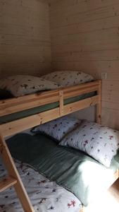 two bunk beds in a room with two pillows at Domek Leśna Przystań 