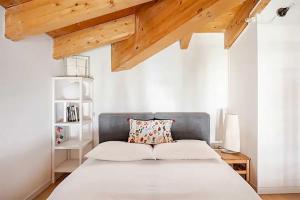 a bedroom with a large bed with a wooden ceiling at Relais Fasanella attico - Lago di Garda in Toscolano Maderno +71 photos