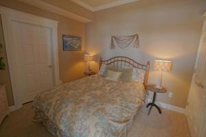 a bedroom with a bed with two lamps and a door at Pier Harbor #2 in Saint Ignace